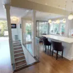 Palo Alto contractor remodeled this home into a stunning, clean masterpiece with glass stair railing, marble countertops and bright white cabinetry, natural sunlight makes the room shine.