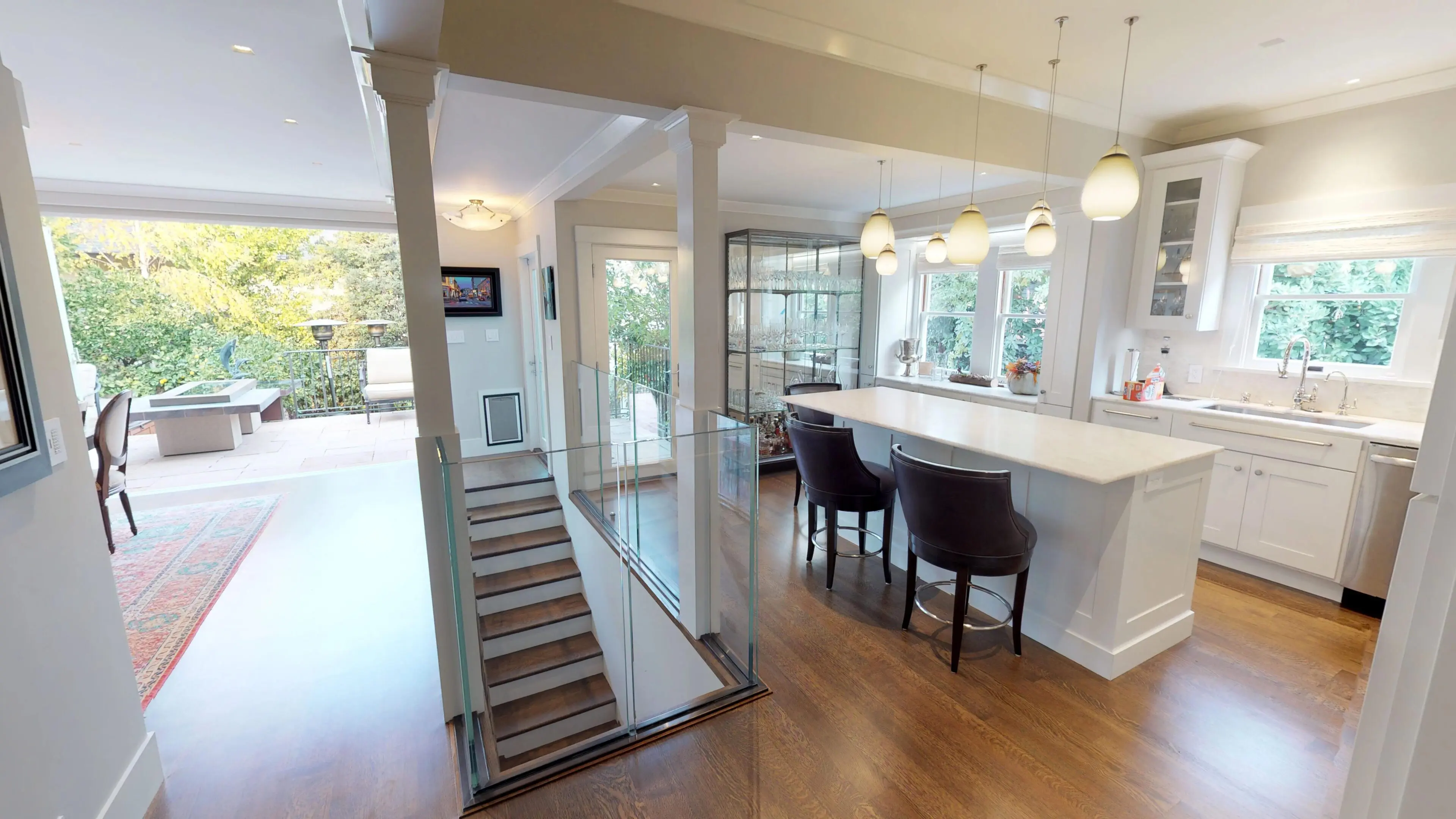 Luxury kitchen addition with countertop island, pendant lights, and staircase in Palo Alto – Sigura Construction