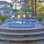 Inground hot tub with tan and gray pavers in Atherton outdoor living remodel