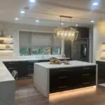 Modern kitchen island in Los Altos Hills home with ebony drawers and gold chandelier
