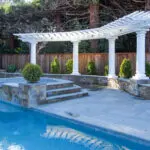 Luxury pool, hot tub, and white-column pergola in Atherton backyard design