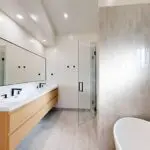 Master bathroom in West San Jose remodel with dual wood-finish sinks and glass-door shower