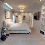 Modern bedroom with a cozy bed and ambient lighting.