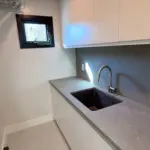 Clean and sharp laundry room with sink.