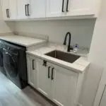 Newly remodeled laundry room with matching grey-veined granite tops