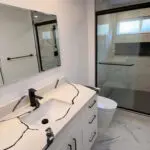 San Jose bathroom remodeling project with glass shower enclosure, matte-black fixtures, and modern stone vanity.