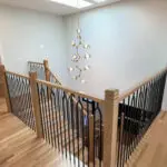 Modern oak staircase with LED risers & arched black balusters.