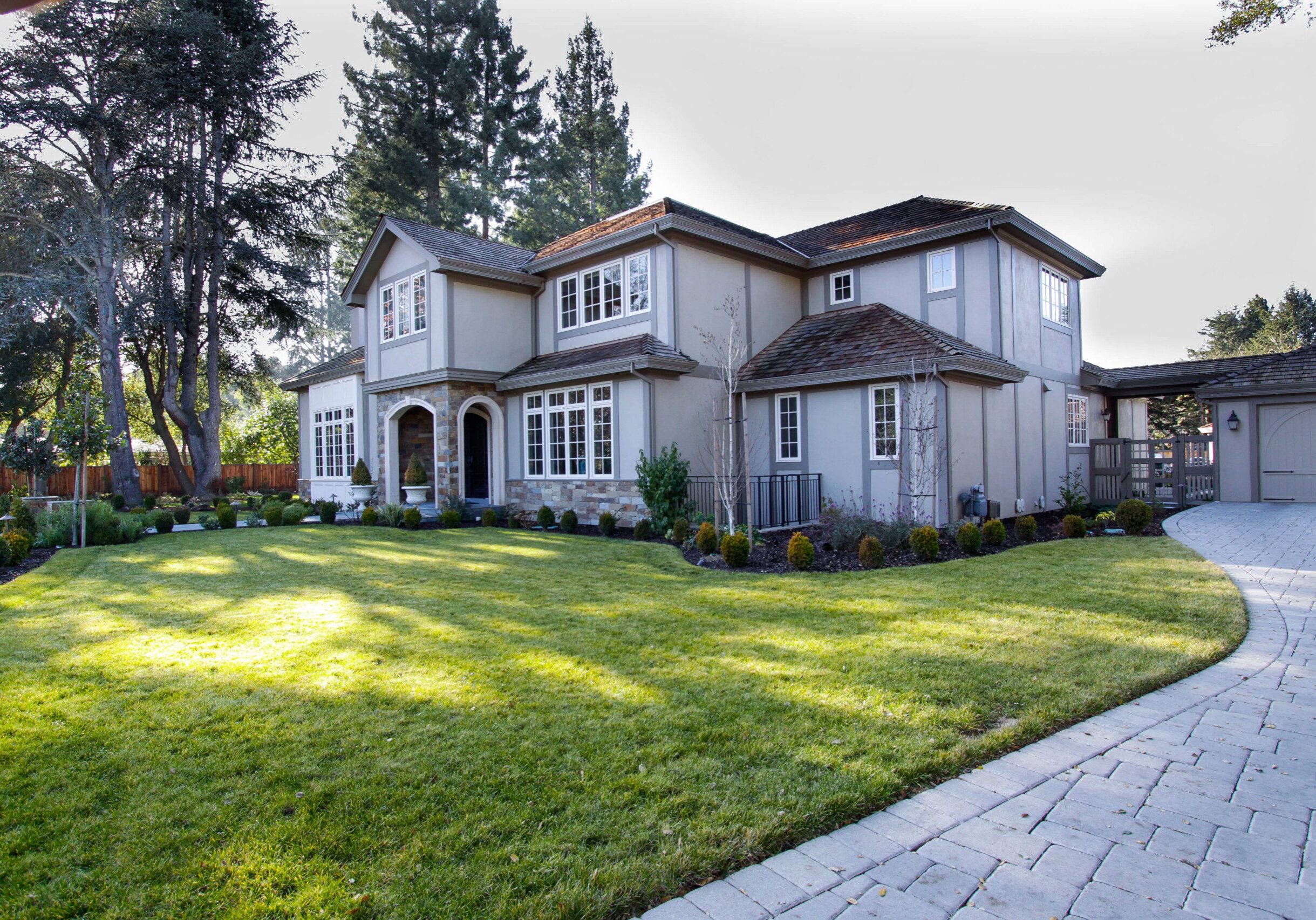 Elegant front yard in Atherton home with paver stone walkway and manicured lawn